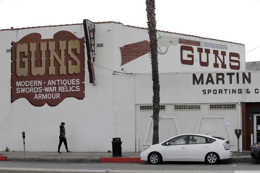 CORRECTS TO CULVER CITY, INSTEAD OF LOS ANGELES Guns are advertised for sale at a gun shop Tuesday, March 24, 2020, in Culver City, Calif. Los Angeles County Sheriff Alex Villanueva said he would like to see gun shops shut down. "We will be closing them, they are not an essential function," Villanueva said. Adding guns to households where more people are at home during a crisis increases the risk that someone will be shot, he said. (AP Photo/Marcio Jose Sanchez)