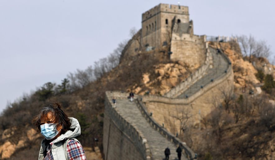 A woman wearing a protective face mask visits the Badaling Great Wall of China after it reopened for business following the new coronavirus outbreak in Beijing, China, Tuesday, March 24, 2020. Beijing's city zoo and parts of the Great Wall of China have reopened to visitors who book in advance, as the capital slowly returns to normal amid a sharp fall in the number of new coronavirus cases. (AP Photo/Andy Wong)