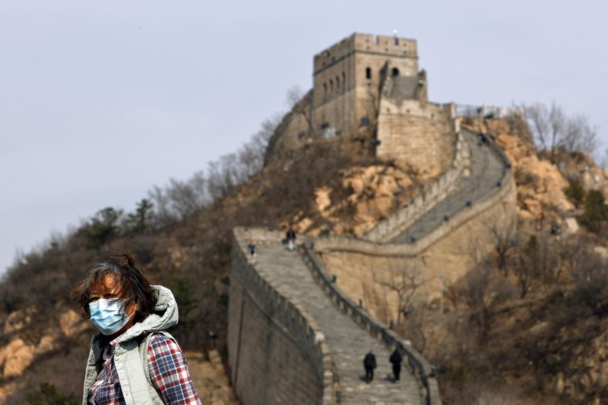 A woman wearing a protective face mask visits the Badaling Great Wall of China after it reopened for business following the new coronavirus outbreak in Beijing, China, Tuesday, March 24, 2020. Beijing's city zoo and parts of the Great Wall of China have reopened to visitors who book in advance, as the capital slowly returns to normal amid a sharp fall in the number of new coronavirus cases. (AP Photo/Andy Wong)