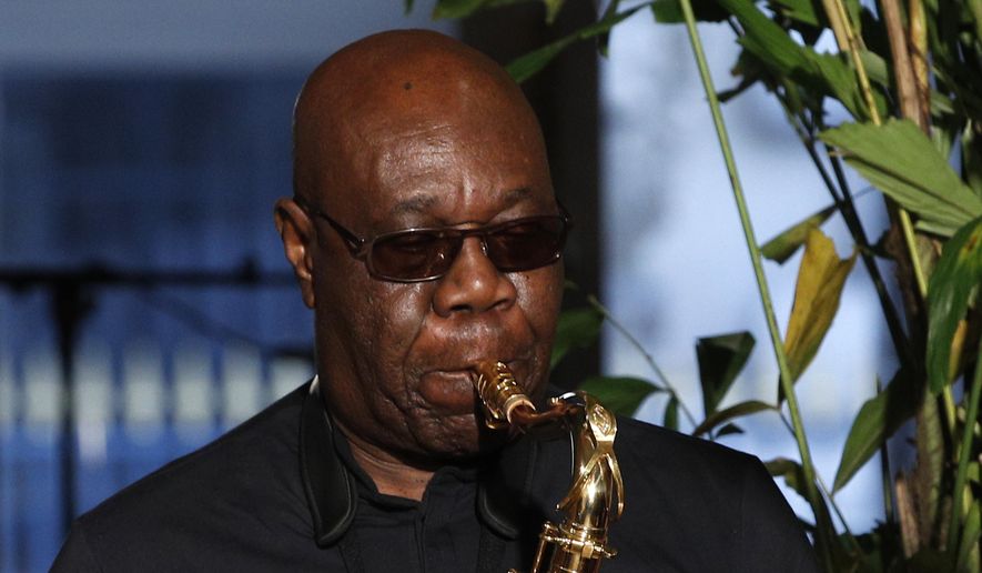 In this Jan. 24, 2018, file photo, saxophonist Manu Dibango performs during Franck Sorbier's Haute Couture Spring-Summer 2018 fashion collection in Paris. Renowned jazz man Manu Dibango, to many the beloved "Papy Groove" who served as an inspiration and pioneer in his art, died on Tuesday from the coronavirus, his official Facebook page announced. He was 86. For most people, the new coronavirus causes only mild or moderate symptoms. For some, it can cause more severe illness. (AP Photo/Christophe Ena, File)