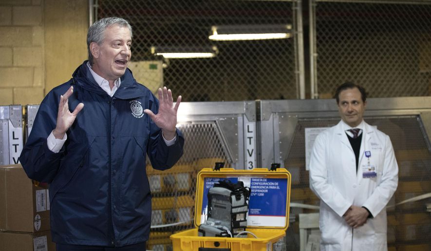 New York City Mayor Bill de Blasio, left, discusses the arrival of a shipment of 400 ventilators with Dr. Steven Pulitzer, the Chief Medical Officer of NYC Health and Hospitals, at the city&#x27;s Emergency Management Warehouse., Tuesday, March 24, 2020, in New York. (AP Photo/Mark Lennihan)