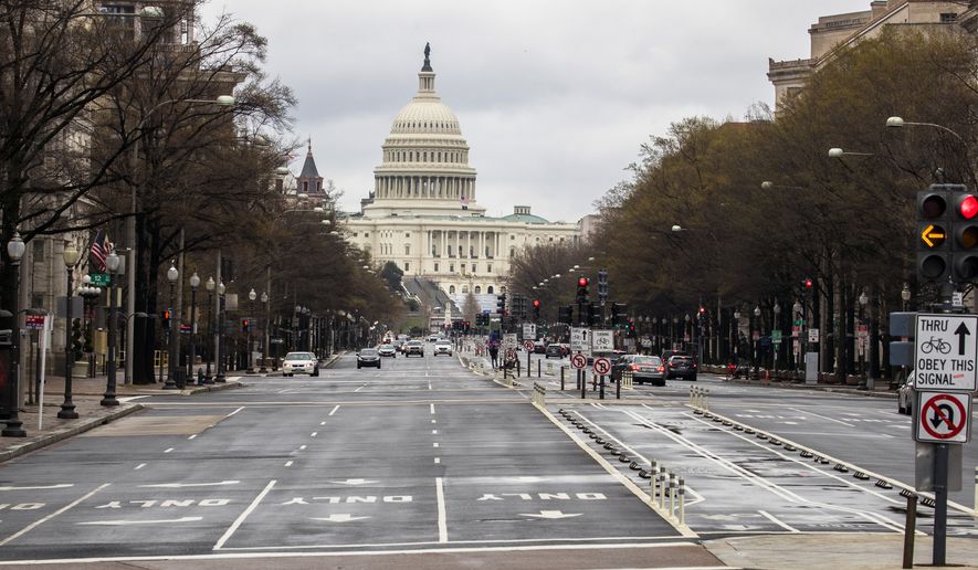 With the U.S. Capitol building in the background, motorists drive on Pennsylvania Avenue NW, Wednesday, March 25, 2020, in Washington. Officials have urged Washington residents to stay home to contain the spread of the coronavirus. (AP Photo/Manuel Balce Ceneta)