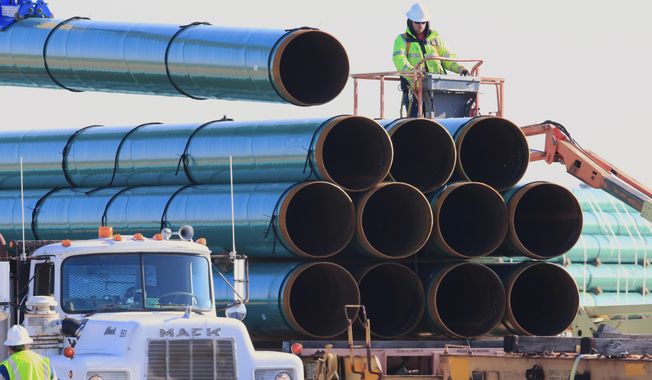 In this May 9, 2015, file photo, workers unload pipes in Worthing, S.D., for the Dakota Access oil pipeline that stretches from the Bakken oil fields in North Dakota to Illinois. A federal judge on Wednesday, March 25, 2020, ordered the U.S. Army Corps of Engineers to conduct a full environmental review of the Dakota Access pipeline, nearly three years after it began carrying oil.  (AP Photo/Nati Harnik, File)