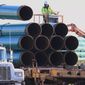 In this May 9, 2015, file photo, workers unload pipes in Worthing, S.D., for the Dakota Access oil pipeline that stretches from the Bakken oil fields in North Dakota to Illinois. A federal judge on Wednesday, March 25, 2020, ordered the U.S. Army Corps of Engineers to conduct a full environmental review of the Dakota Access pipeline, nearly three years after it began carrying oil.  (AP Photo/Nati Harnik, File)