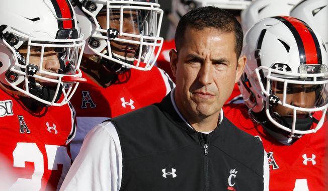 FILE - In this Saturday, Nov. 9, 2019, file photo, Cincinnati head coach Luke Fickell takes the field with his players before the first half of an NCAA college football game against Connecticut, in Cincinnati. Normally, in March, college football teams would be preparing for the upcoming season. Because of the new coronavirus pandemic, coaches are trying to figure out how to recreate some of what has been lost. Fickell said his goal is to try give his players a routine, including workout regimens they can do on their own without access to local gyms. They will also have online meetings with position groups and assistant coaches. (AP Photo/John Minchillo, File)