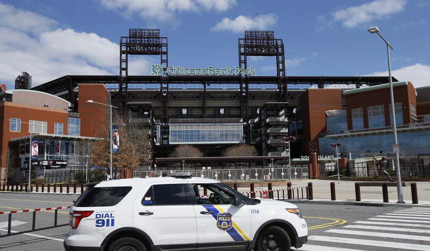 In this March 24, 2020, file photo, a Police vehicle blocks a street near Citizens Bank Park, home of the Philadelphia Phillies baseball team, in Philadelphia. On MLB’s opening day, ballparks will be empty with the start of the season on hold because of the coronavirus pandemic. (AP Photo/Matt Slocum, File) **FILE**