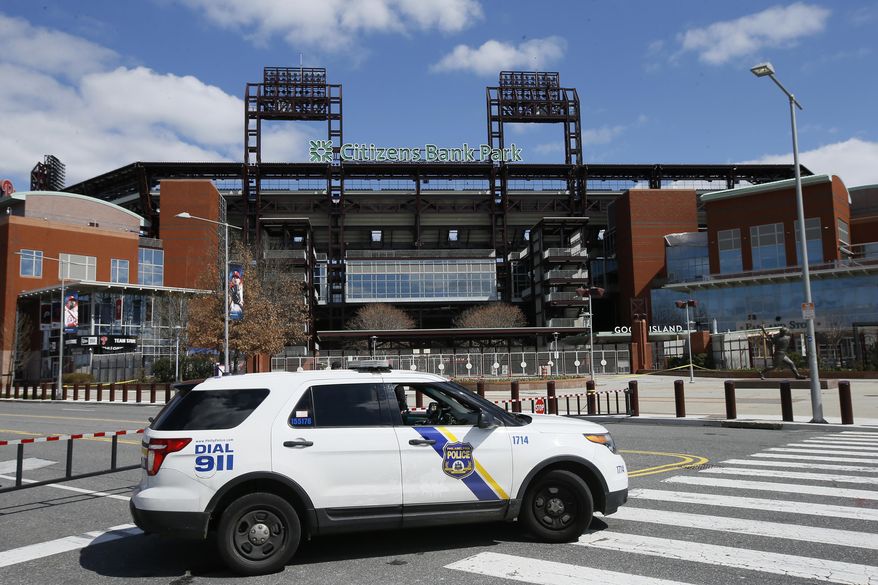 In this March 24, 2020, file photo, a Police vehicle blocks a street near Citizens Bank Park, home of the Philadelphia Phillies baseball team, in Philadelphia. On MLB’s opening day, ballparks will be empty with the start of the season on hold because of the coronavirus pandemic. (AP Photo/Matt Slocum, File) **FILE**