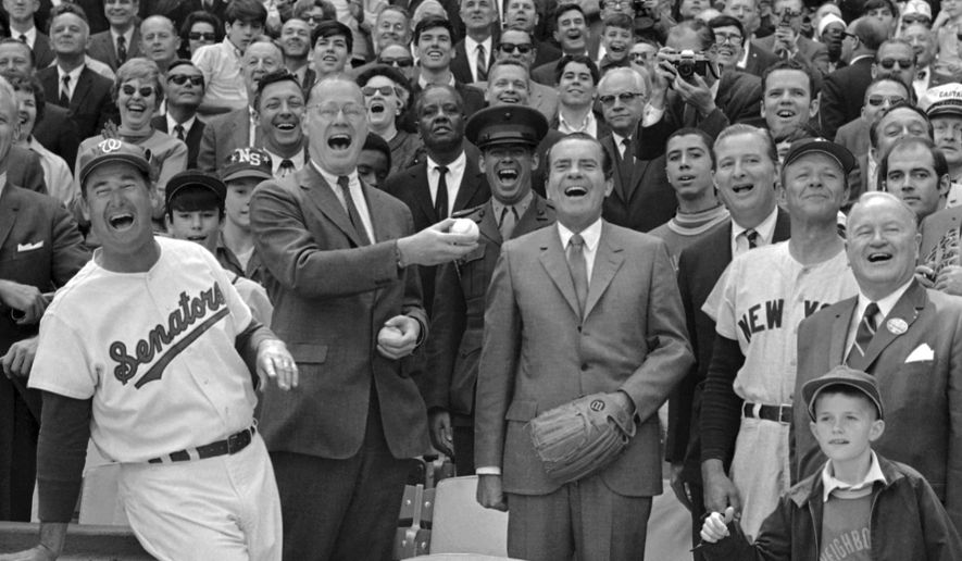 FILE - In this April 7, 1969, file photo, President Richard Nixon and Baseball Commissioner Bowie Kuhn, center-left, join Washington Senators manager Ted Williams, left, in a round of laughter before the chief executive tossed out the first ball in an opening day baseball game at RFK Stadium in Washington. (AP Photo/File)