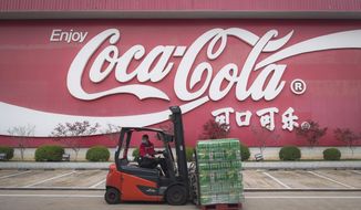 In this Tuesday, March 24, 2020, photo released by China&#39;s Xinhua News Agency, a worker wearing a face mask drives a forklift at a Swire Coca-Cola Beverages Hubei Limited plant in Wuhan in central China&#39;s Hubei Province. According to Chinese state media, the plant restarted some production lines on Monday. While many migrant workers across China remain trapped by travel bans due to the coronavirus, some industrial production has returned to action, including in the crucial auto manufacturing industry, which is largely based in Wuhan, and in businesses that provide critical links in global supply chains. The new coronavirus causes mild or moderate symptoms for most people, but for some, especially older adults and people with existing health problems, it can cause more severe illness or death. (Xiao Yijiu/Xinhua via AP)