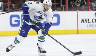 FILE - In this Jan. 12, 2015, file photo, Vancouver Canucks defenseman Ryan Stanton is shown during the first period of an NHL hockey game against the Philadelphia Flyers in Philadelphia. Stanton, now playing for the American Hockey League Ontario Reign, drove 27 hours with his wife, 18-month-old daughter, mother-in-law and dog from Southern California to St. Albert, Alberta. The trip was prompted after the new coronavirus pandemic put the American Hockey League Ontario Reign defenseman&#x27;s season on hold last week. (AP Photo/Chris Szagola, File)