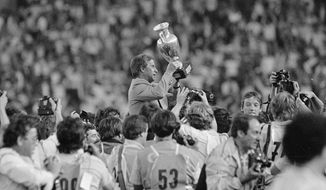 FILE - In this June 27, 1984 file photo, French soccer team coach Michel Hidalgo raises the 1984 European Championship cup as he is carried across the Parc des Princes Stadium in Paris. The French Football Federation said on its website that Hidalgo died on Thursday March 26, 2020. He was 87. (AP Photo, FILE)