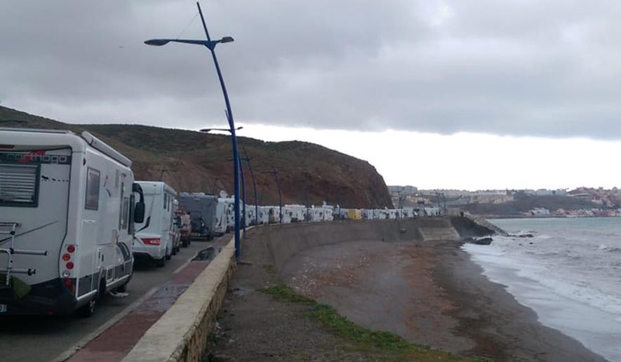 In this photo taken on Tuesday, March 24, 2020, stranded tourists in motor homes queue in northern Morocco, near the Spanish enclave of Ceuta. Tourists were stranded in the region due to a lockdown and other strict measures taken by Moroccan authorities to limit the spread of the coronavirus. The new coronavirus causes mild or moderate symptoms for most people, but for some, especially older adults and people with existing health problems, it can cause more severe illness or death. (Andy McKettrick via AP)