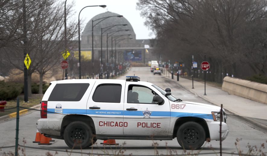 A Chicago police officer blocks the road to the Adler Planetarium along Lake Michigan Thursday, March 26, 2020, in Chicago. On Thursday morning, Chicago Police began turning joggers and others away from the city&#39;s lakefront trails amid fears of the spread of the coronavirus, hours after Mayor Lori Lightfoot threatened to shut them down if people would not stop crowding the areas. (AP Photo/Charles Rex Arbogast)