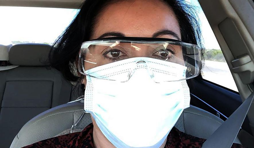 This March 23, 2020 photo provided by Margarita Silva shows her wearing her husband’s land surveyor goggles, a mask she borrowed from a friend and medical gloves she got from a hardware store outside the La Palma Detention Center in Eloy, Ariz. Attorneys and judges in U.S. immigration courts are trying to protect themselves from the coronavirus with borrowed masks and hand sanitizer. The Trump administration has delayed hearings for immigrants who aren't in detention but is moving forward for those who are. (Margarita Silva via AP)