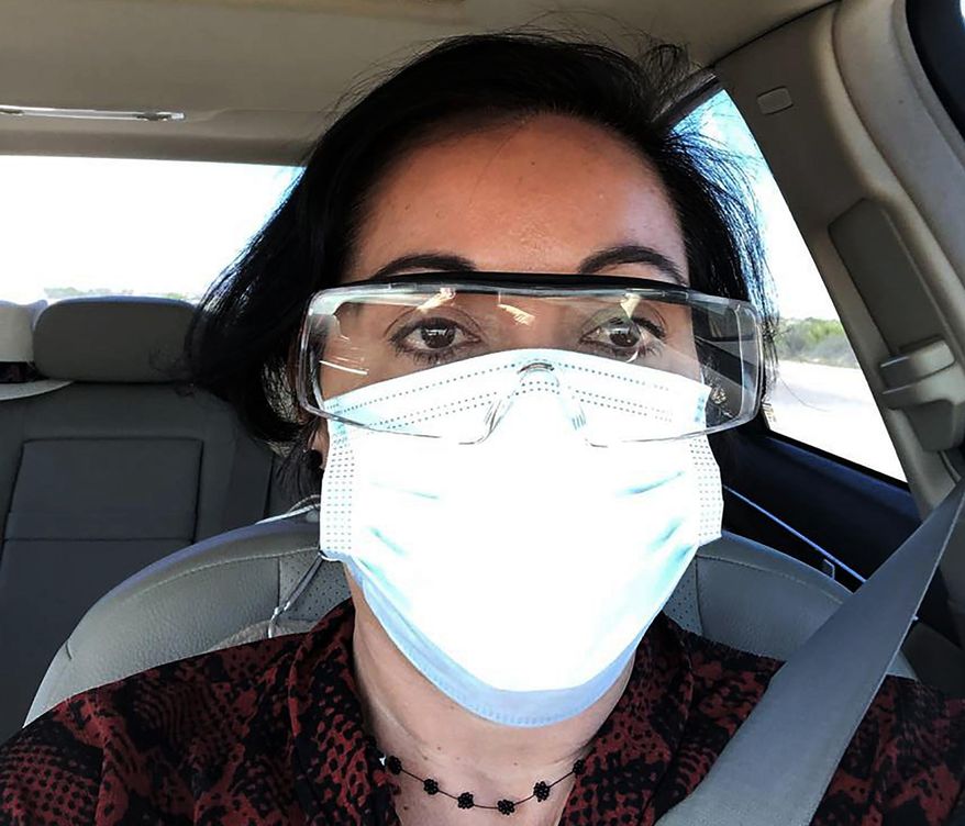 This March 23, 2020 photo provided by Margarita Silva shows her wearing her husband’s land surveyor goggles, a mask she borrowed from a friend and medical gloves she got from a hardware store outside the La Palma Detention Center in Eloy, Ariz. Attorneys and judges in U.S. immigration courts are trying to protect themselves from the coronavirus with borrowed masks and hand sanitizer. The Trump administration has delayed hearings for immigrants who aren't in detention but is moving forward for those who are. (Margarita Silva via AP)