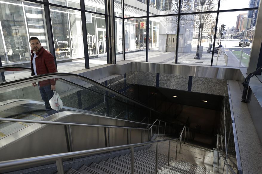 A man exits a subway station in the Seaport District, in Boston, Thursday, March 26, 2020. Many people are working from home while many businesses have closed indefinitely because of the coronavirus, leaving portions of the city nearly empty. The new coronavirus causes mild or moderate symptoms for most people, but for some, especially older adults and people with existing health problems, it can cause more severe illness or death. (AP Photo/Steven Senne)