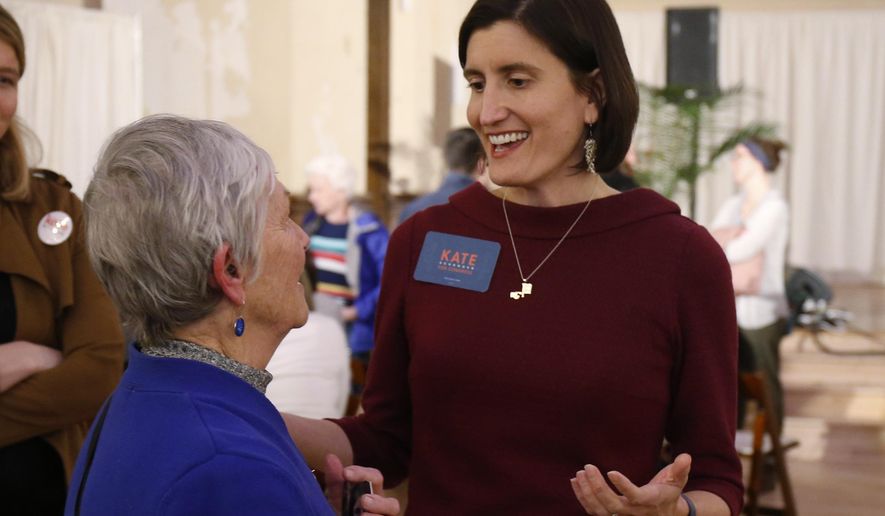 FILE—In this Feb. 18, 2020, file photo,Kate Schroder, Democratic candidate for Ohio's first congressional district, right, greets a woman following a question and answer session held by the Bold New Democracy Work Group, in Cincinnati. In Ohio, candidates such as Schroder and Nikki Foster nearly emptied their campaign coffers in the closing days before March 17, and now are focusing on social media and phone banks to keep up their campaigns while awaiting clarity on when the primary will end amid the coronavirus stay-home orders. (AP Photo/Gary Landers, File)