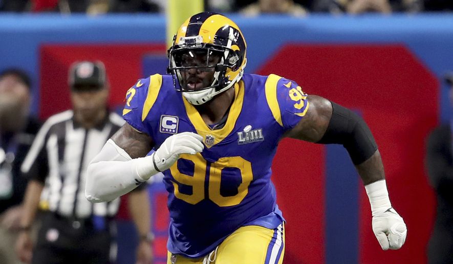 In this Feb. 3, 2019, photo, Los Angeles Rams Michael Brockers is shown in action against the New England Patriots during NFL Super Bowl 53 in Atlanta. Brockers is re-signing with the Los Angeles Rams after his free agent deal with the Ravens fell through, apparently because Baltimore's team doctors couldn't examine him properly due to the coronavirus pandemic. Brockers' representatives at Team Sports Agency confirmed the surprising reversal Friday, March 27, 2020. (AP Photo/Gregory Payan) **FILE**