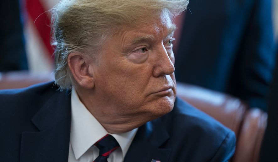 President Donald Trump listens to lawmakers before signing the coronavirus stimulus relief package in the Oval Office at the White House, Friday, March 27, 2020, in Washington. (AP Photo/Evan Vucci)