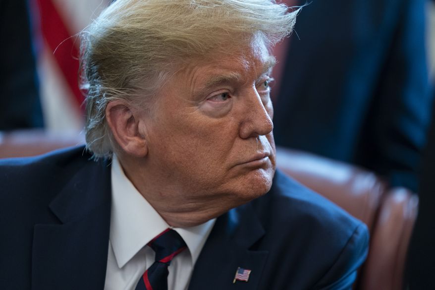 President Donald Trump listens to lawmakers before signing the coronavirus stimulus relief package in the Oval Office at the White House, Friday, March 27, 2020, in Washington. (AP Photo/Evan Vucci)
