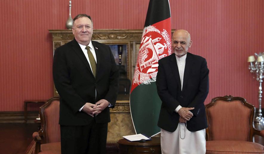U.S. Secretary of State Mike Pompeo, left, stands with Afghan President Ashraf Ghani, at the Presidential Palace in Kabul, Afghanistan, Monday, March 23, 2020. Pompeo was in Kabul on an urgent visit Monday to try to move forward a U.S. peace deal signed last month with the Taliban, a trip that comes despite the coronavirus pandemic, at a time when world leaders and statesmen are curtailing official travel. (Afghan Presidential Palace via AP)
