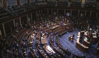 In this file image from video, members of the House practice social distancing as they sit on the floor and in the public gallery above during debate on the coronavirus stimulus package on the floor of the House of Representatives at the U.S. Capitol in Washington, Friday, March 27, 2020. (House Television via AP)