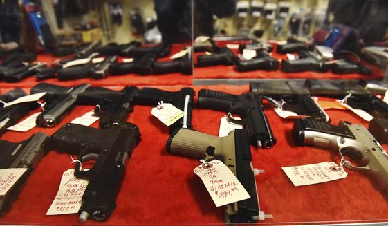 In this file photo, handguns sit in a display case at a gun store in Wilkes-Barre, Pa., Wednesday, March 18, 2020. (Sean McKeag/The Citizens&#39; Voice via AP) **FILE**