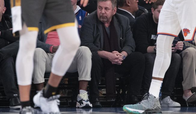 FILE - In this March 6, 2020, file photo, New York Knicks owner James Dolan, center, watches the first half of an NBA basketball game between the Knicks and the Oklahoma City Thunder at Madison Square Garden in New York. Dolan, the executive chairman of Madison Square Garden Company and owner of the Knicks, has tested positive for the coronavirus. The Knicks announced Dolan’s diagnosis Saturday night, March 28. It is not clear when he was tested or when he received the diagnosis. (AP Photo/Mary Altaffer, File)