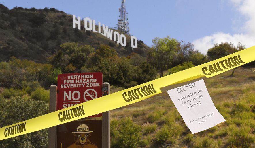 A sign is seen at the entrance to Innsdale Trail near the Hollywood Sign, Saturday, March 28, 2020, in Los Angeles. With cases of coronavirus surging and the death toll surpassing 100, lawmakers are pleading with cooped-up Californians to spend a second weekend at home to slow the spread of the infections. It has been more than a week since Gov. Gavin Newsom barred 40 million residents from going outdoors except for essentials. Even so, reports of crowds have prompted local and state officials to warn that ignoring social distancing, park and beach closures could spread the virus, which already is surging. (AP Photo/Mark J. Terrill)