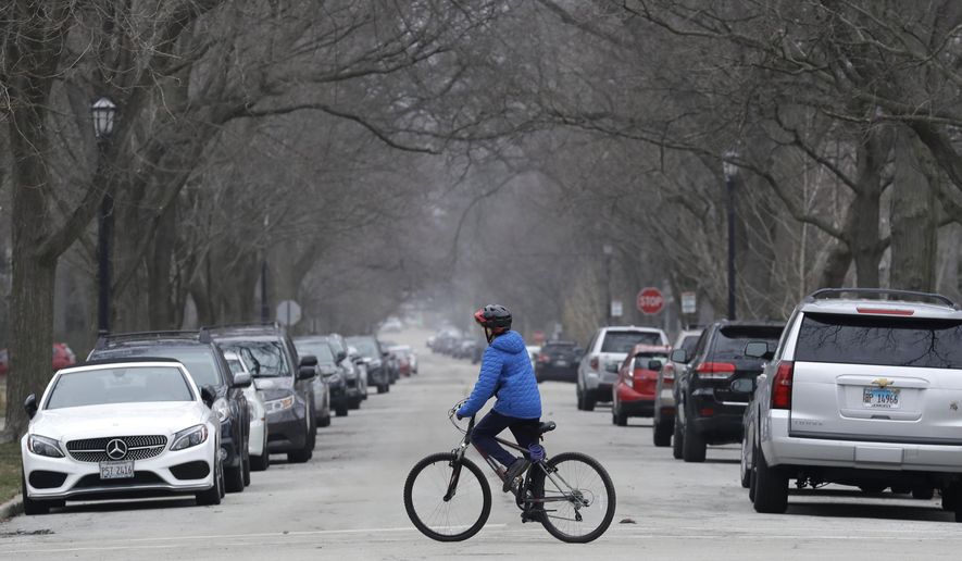 A resident rides his bicycle on the street in Evanston, Ill., Friday, March 27, 2020. The conservative watchdog group Judicial Watch filed the class-action suit last month against Evanston, Illinois. The city of about 75,000 people outside Chicago in Cook County became the first locality in 2021 to implement a reparations program for Black people. (AP Photo/Nam Y. Huh)