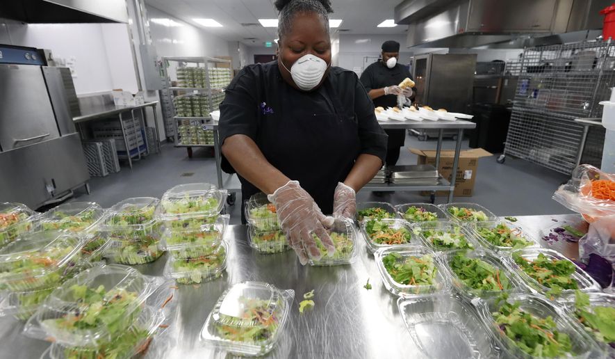 Chef Rose Barrett prepares dinner salads that would accompany the chicken tetrazzini being made by the staff in the commercial kitchen at The Potters House Church in Dallas, Friday, March 27, 2020. The church's kitchen staff planned on making and donating 1,000 meals that would be delivered to area healthcare workers and first responders as they help in the fight against the coronavirus outbreak. The kitchen which is part of the church founded by Bishop T.D. Jakes, typically prepares meals for banquets, high school graduations and community functions being held at the church's event center. (AP Photo/Tony Gutierrez)