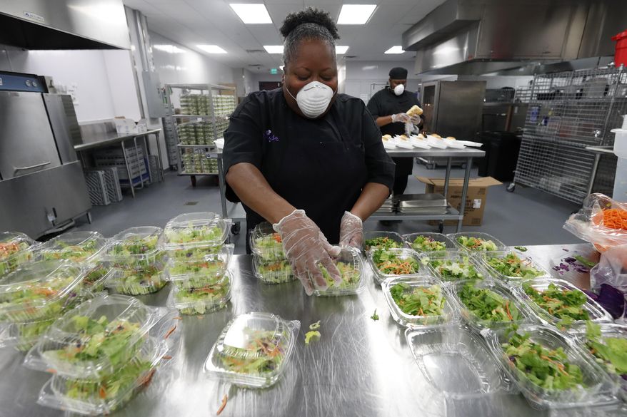Chef Rose Barrett prepares dinner salads that would accompany the chicken tetrazzini being made by the staff in the commercial kitchen at The Potters House Church in Dallas, Friday, March 27, 2020. The church's kitchen staff planned on making and donating 1,000 meals that would be delivered to area healthcare workers and first responders as they help in the fight against the coronavirus outbreak. The kitchen which is part of the church founded by Bishop T.D. Jakes, typically prepares meals for banquets, high school graduations and community functions being held at the church's event center. (AP Photo/Tony Gutierrez)