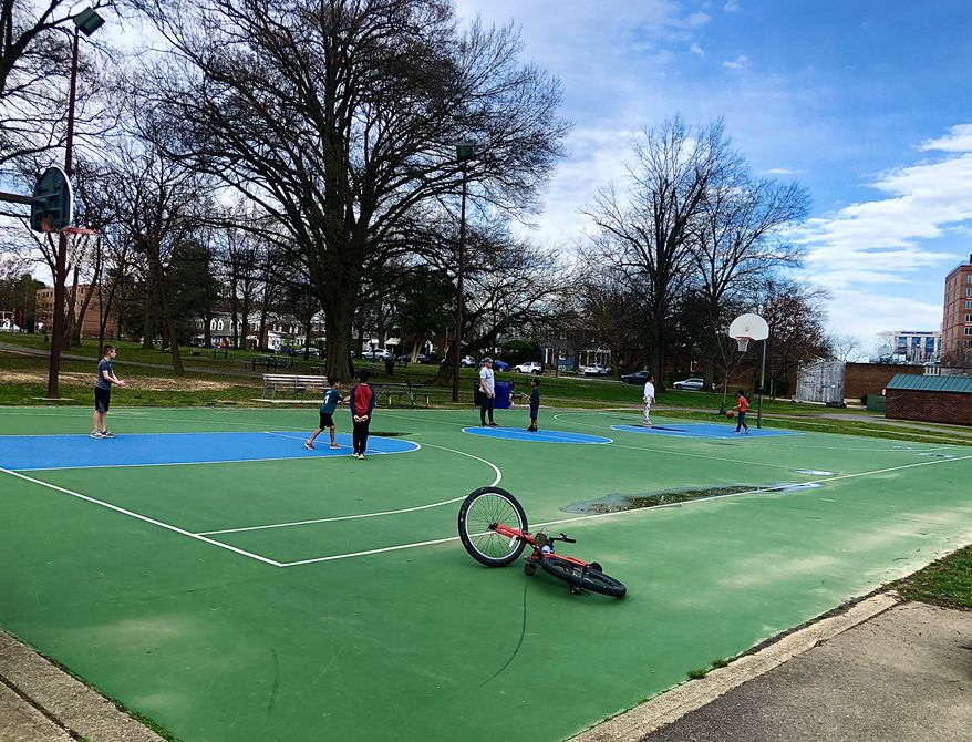 A small group of people play basketball at Quincy Park in Arlington, Virginia before public parks were closed. (Robert Banez/All-Pro Reels)