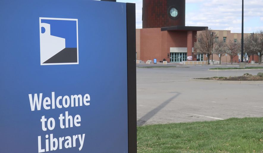 In this photo from Friday, March 28, 2020, the parking lot of the Topeka and Shawnee County Public Library sits empty with the library closed in Topeka, Kan. because of the coronavirus outbreak. (AP Photo/John Hanna) ** FILE **