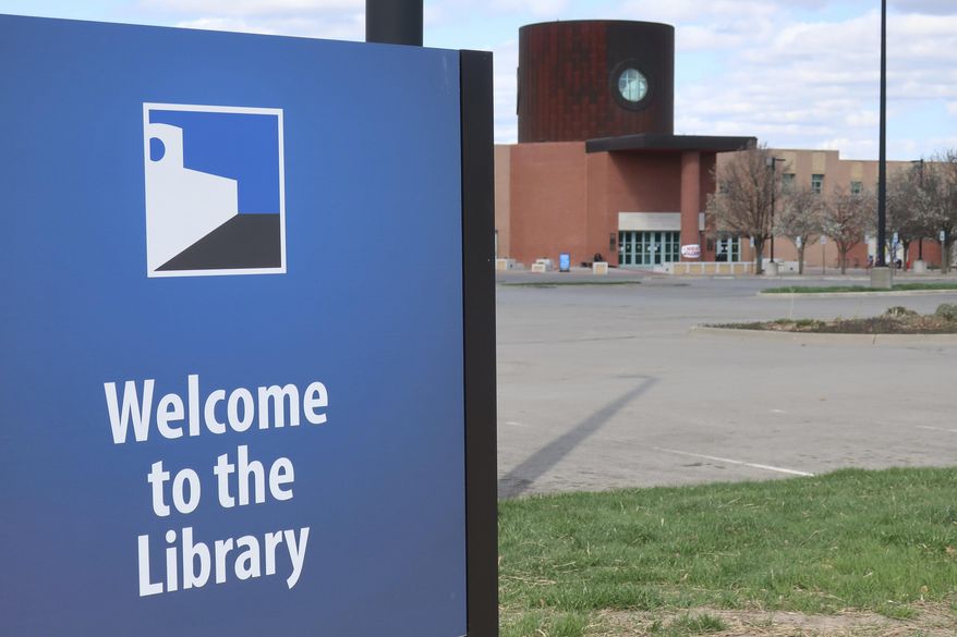 In this photo from Friday, March 28, 2020, the parking lot of the Topeka and Shawnee County Public Library sits empty with the library closed in Topeka, Kan. because of the coronavirus outbreak. (AP Photo/John Hanna) ** FILE **