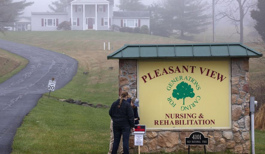 In the fog, Carroll County Health Department personnel place a &amp;quot;no trespassing&amp;quot; sign by the driveway of the Pleasant View Nursing Home, in Mount Airy, Md., Sunday, March 29, 2020. Maryland&#39;s governor said Saturday night that the nursing home had been struck by an outbreak of COVID-19. (AP Photo/Jacquelyn Martin) ** FILE **