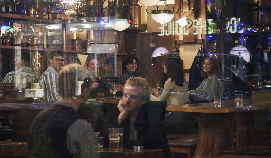 People sit in a bar in Stockholm, Wednesday, March 25, 2020. The streets of Sweden&#x27;s capital are quiet but not deserted. Sweden has some of the most relaxed measures in Europe in the fight against the coronavirus outbreak. So far, only gatherings of over 500 people are banned and elementary and middle schools remain open. The new coronavirus causes mild or moderate symptoms for most people, but for some, especially older adults and people with existing health problems, it can cause more severe illness or death. (AP Photo/David Keyton)