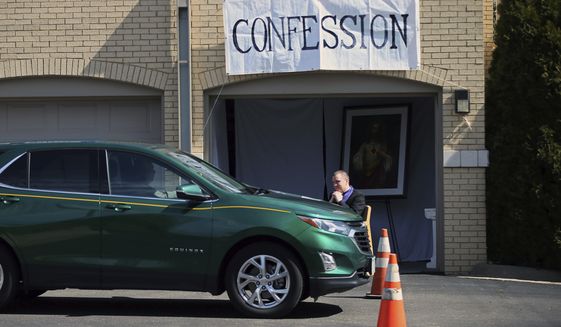 Father Bryce Evans hears confession at the drive-up confession site of St. Maron&#39;s Maronite Catholic Church in northeast Minneapolis Monday, March 39, 2020 as efforts continue to slow down the coronavirus in the state. The new coronavirus causes mild or moderate symptoms for most people, but for some, especially older adults and people with existing health problems, it can cause more severe illness or death. (AP Photo/Jim Mone)