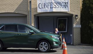 Father Bryce Evans hears confession at the drive-up confession site of St. Maron&#39;s Maronite Catholic Church in northeast Minneapolis Monday, March 39, 2020 as efforts continue to slow down the coronavirus in the state. The new coronavirus causes mild or moderate symptoms for most people, but for some, especially older adults and people with existing health problems, it can cause more severe illness or death. (AP Photo/Jim Mone)