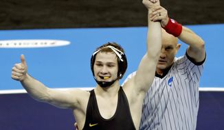 FILE - In this March 23, 2019, file photo, Iowa&#39;s Spencer Lee, left, celebrates his win over Virginia&#39;s Jack Mueller (not shown) in their 125-pound match in the finals of the NCAA wrestling championships in Pittsburgh. Lee has been voted the winner of the Dan Hodge Trophy as the most dominant college wrestler in the nation. Lee received 52 of a possible 57 first-place votes,  WIN magazine announced Monday, March 30, 2020.  (AP Photo/Gene J. Puskar, File)