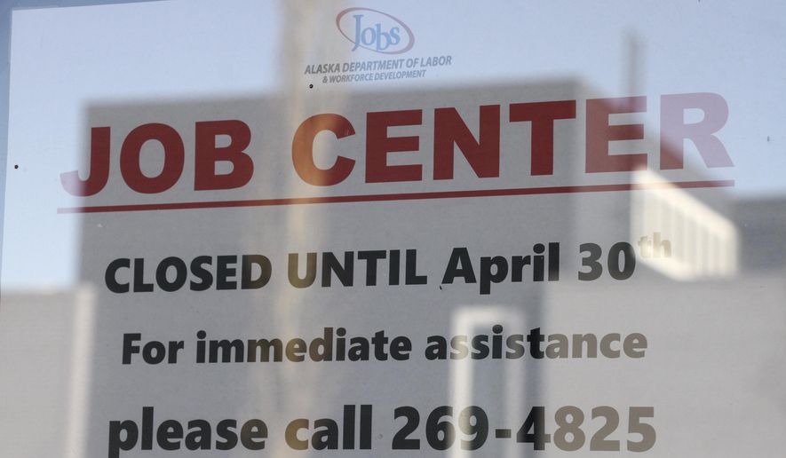 A sign saying that the Jobs Center at the Alaska Department of Labor and Workforce Development office in midtown Anchorage, Alaska, is closed through the end of April is shown Monday, March 30, 2020. (AP Photo/Mark Thiessen)