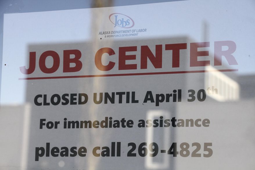 A sign saying that the Jobs Center at the Alaska Department of Labor and Workforce Development office in midtown Anchorage, Alaska, is closed through the end of April is shown Monday, March 30, 2020. (AP Photo/Mark Thiessen)