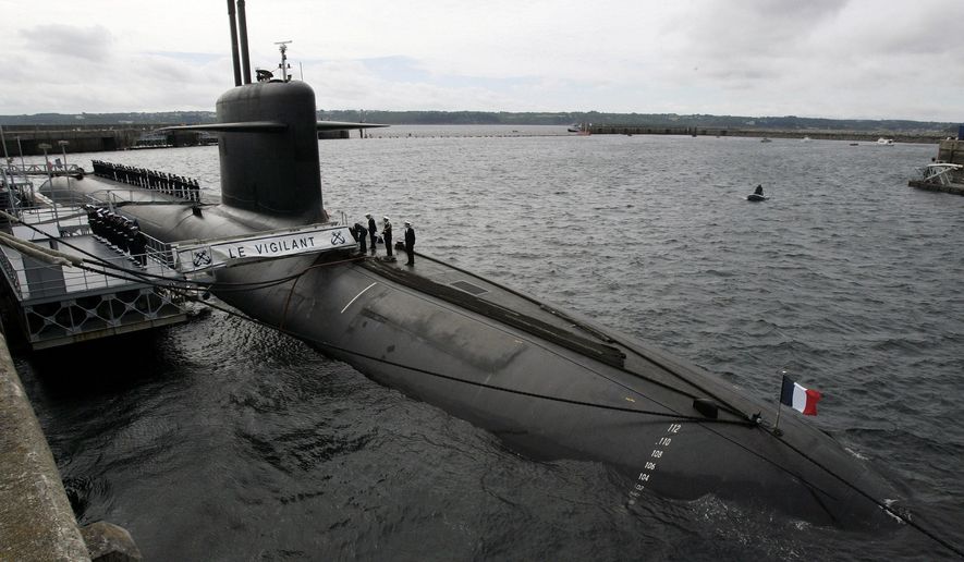 FILE - In this July 13, 2007 file photo, French Marine officers wait atop "Le Vigilant" nuclear submarine at L'Ile Longue military base, near Brest, Brittany. Stealthily cruising the ocean deeps, deliberately hiding from the world now in turmoil, the crews of nuclear-armed submarines may be among the last pockets of people anywhere who are still blissfully unaware of how the coronavirus pandemic is turning life upside down. The new coronavirus causes mild or moderate symptoms for most people, but for some, especially older adults and people with existing health problems, it can cause more severe illness or death. (AP Photo/Francois Mori, Pool, File)