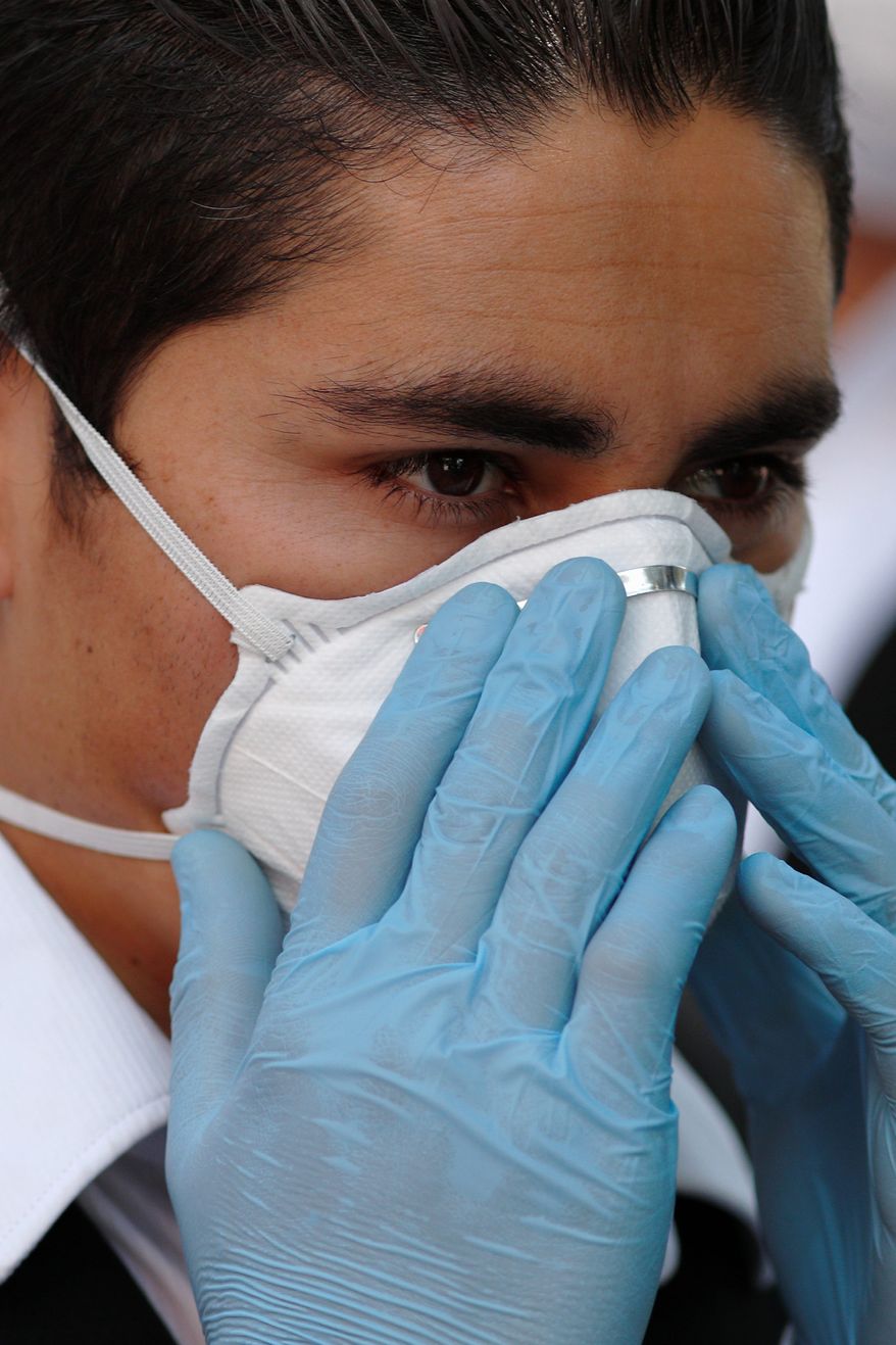 A parking attendant adjusts his face mask as he guides drivers arriving for COVID-19 tests, outside private laboratory Biomedica de Referencia, in the Lomas Virreyes neighborhood of Mexico City, Thursday, March 26, 2020. For most people, the coronavirus causes mild or moderate symptoms, such as fever and cough that clear up in two to three weeks. The coronavirus pandemic could be especially deadly in Mexico because of the country's high rates of obesity and diabetes, a coalition of consumer and health advocacy groups said Wednesday.(AP Photo/Rebecca Blackwell)