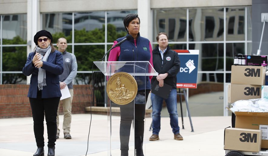 District of Columbia Mayor Muriel Bowser, center, listens to a reporter&#39;s question during a press conference about the District&#39;s coronavirus response, Tuesday, March 31, 2020, in Washington. The District of Columbia has issued a stay-home order for all residents as the number of positive infections from the new coronavirus continue to rise. (AP Photo/Patrick Semansky)