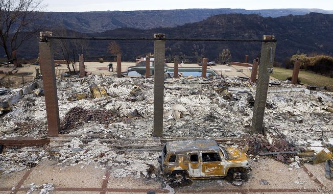 FILE - In this Dec. 3, 2018, file photo, a vehicle rests in front of a home leveled by the Camp Fire in Paradise, Calif. California power regulators are weighing a recommendation to back off plans to fine Pacific Gas and Electric an additional $462 million for igniting a series of Northern California 2018 deadly wildfires rather than risk that the harsher punishment will scuttle the utility&#x27;s plan to emerge from bankruptcy protection, the state&#x27;s Public Utilities Commission said in a document made public Monday, March 30, 2020. (AP Photo/Noah Berger, File)