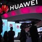 In this Oct. 31, 2019, file photo, attendees walk past a display for 5G services from Chinese technology firm Huawei at the PT Expo in Beijing. (AP Photo/Mark Schiefelbein, File)