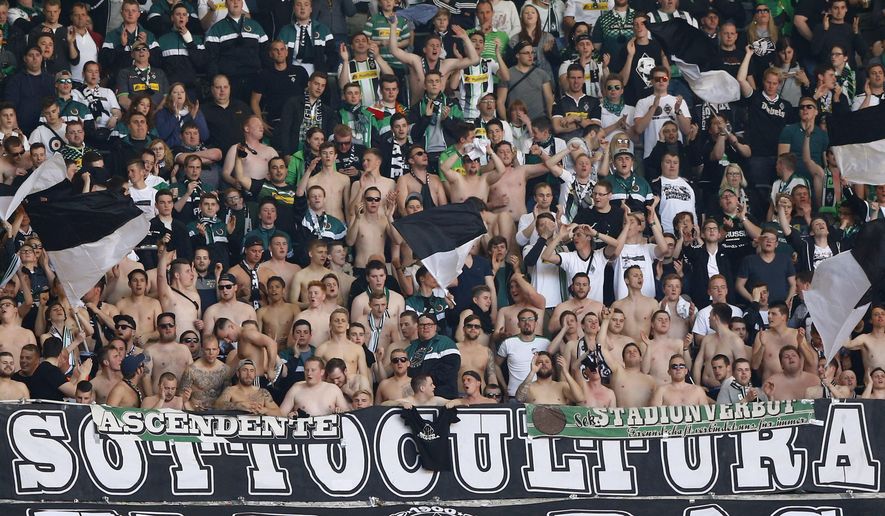 FILE-In this April 30, 2016 file photo Moenchengladbach supporter cheer their team during the German Bundesliga soccer match between FC Bayern Munich and Borussia Moenchengladbach at the Allianz Arena stadium in Munich, Germany. The league has been suspended through April 30 at least due to the coronavirus outbreak and it’s likely that fans will be excluded if it resumes. Public life in Germany has been largely shut down to contain the virus, and clubs are resigned to more so-called “ghost games” without supporters if the season is to be concluded. (AP Photo/Matthias Schrader)