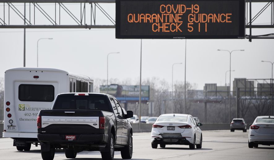 A road sign over Interstate 80 in Omaha, Neb., directs motorists to contact 511 for Covid-19 quarantine guidance, Tuesday, March 31, 2020. Travelers coming back to Nebraska from out of state are advised to self-quarantine for 14 days. This includes snowbirds returning to Nebraska after having spent the winter in places like Arizona, Florida, or Texas, or those visiting secondary residences within Nebraska. However, the guidance to self-quarantine does not apply to commuters or workers in the transportation industry. (AP Photo/Nati Harnik)