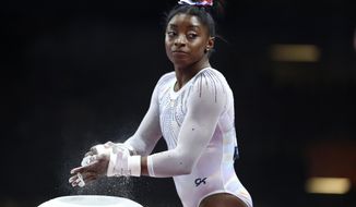FILE - In this Oct. 10, 2019, file photo, Simone Biles of the United States gets ready to perform on the uneven bars in the women&#39;s all-around final at the Gymnastics World Championships in Stuttgart, Germany. Biles is pressing on to the 2021 Olympics. While she&#39;s confident her body will be fine next summer, she is concerned about the mental toll of another year of training.  (AP Photo/Matthias Schrader, Fle)